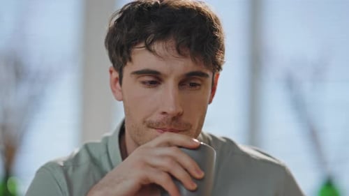 Thoughtful Guy Drinking Coffee in Apartment Alone Close Up Man Holding Cup Home