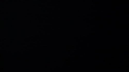 Flashes of lightning in the night sky among thunderclouds.