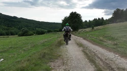Aerial Shot of a Motocross Rider on a Journey on a Dirt and Dusty Country Road Driving Fast and