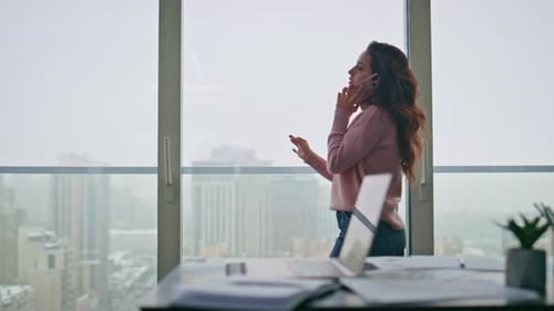 Serious Manager Having Call Holding Cellphone Near Panoramic Window at Office
