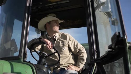 Handsome Male Farmer in Cowboy Hat in Tractor on Sunny Farm Adult