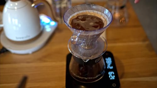 Close up of brewing pour-over drip coffee on a wooden table