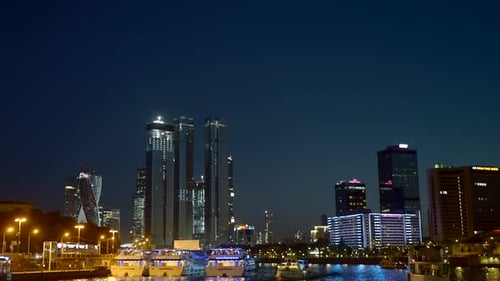 View from the river on the night city with skyscrapers and many lights