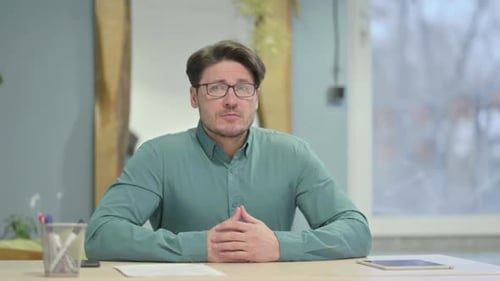 Pensive Mature Adult Man Thinking while Sitting at Work