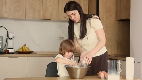 Happy Woman and Child Baking Together in Kitchen