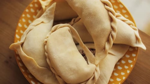 Homme cuisinant des empanadas, tarte argentine, tarte aux samosas, boulangerie traditionnelle argentine, garniture de chef