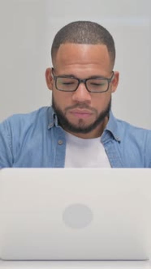 Young adult man with laptop looking at camera