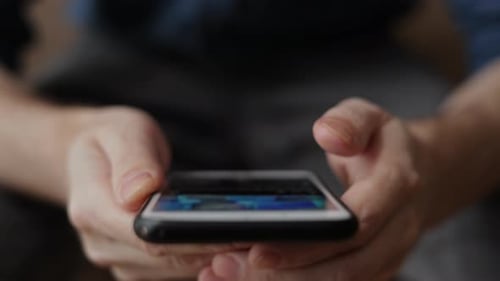 A Man Uses a Smartphone Flips Through Photos Watches the News Typing Uses the Internet Modern