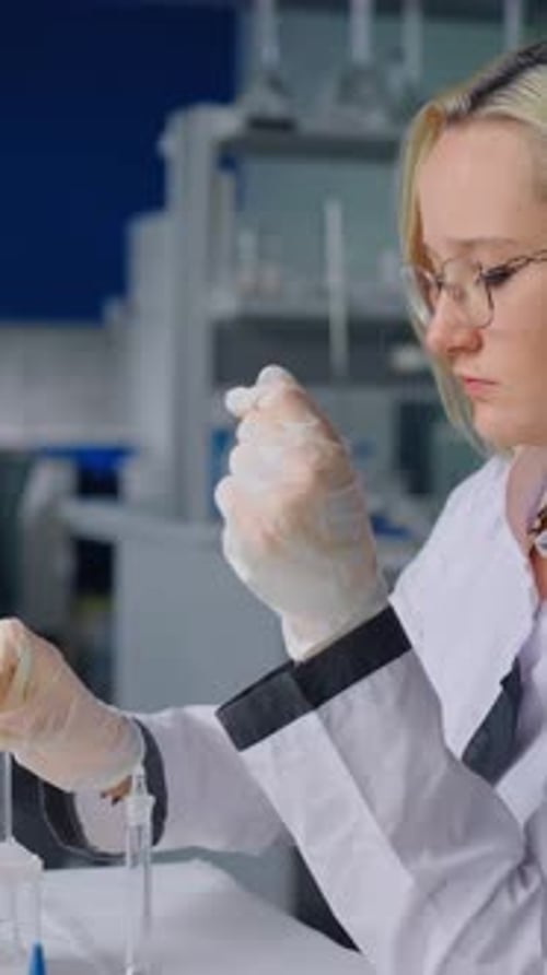 Woman Scientist Handling Test Tubes with Colorful Liquids