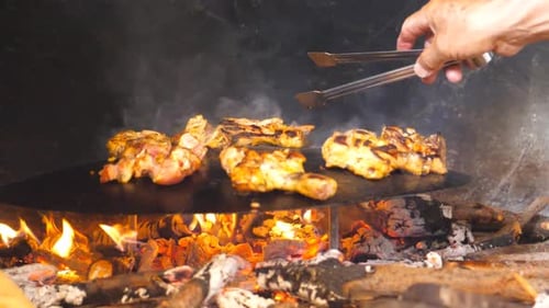 Unrecognizable Cook Turning Grilled Chicken Legs