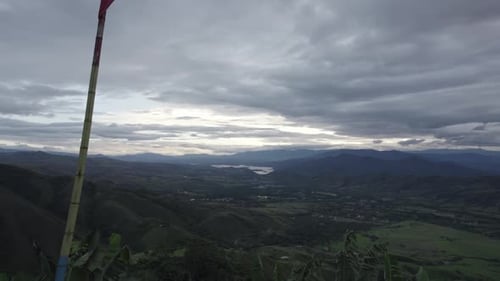 Waving Flag Of Colombia In Scenic Nature Landscape On A Cloudy Day - drone shot