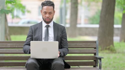 Thumbs Down by Businessman Using Laptop Outdoor