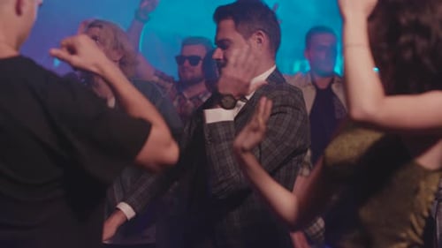 People Dancing at a Nightclub with Blue Lighting