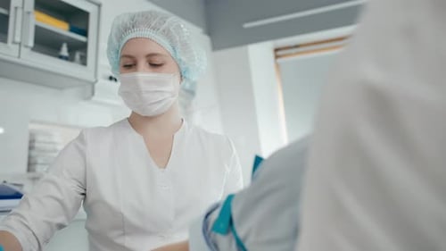 Hospital nurse taking blood sample for coronavirus antibodies test indoors