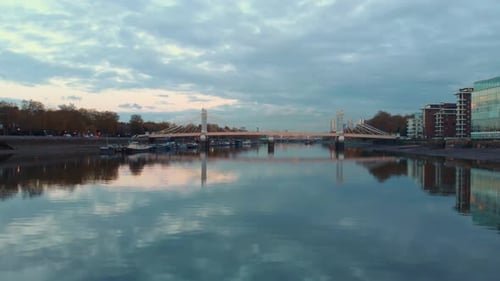 dolly forward rising revela una toma con un Zumbido del puente Albert y la ciudad de Londres al atardecer