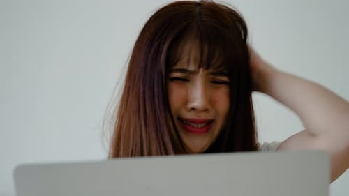 Young Asian woman read bad news on laptop look desperate, feels stressed due unsaved document