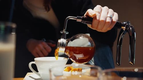 Barista Pouring Freshly Brewed Siphon Coffee