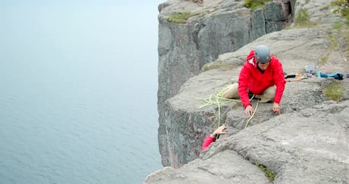 Climber helps friend adjust gear on cliff face in Yosemite national park slow motion