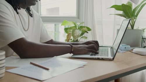 Black Male Developer Coding on Laptop at Desk Indoors