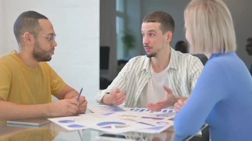 Diverse Team Discussing Data in Modern Office