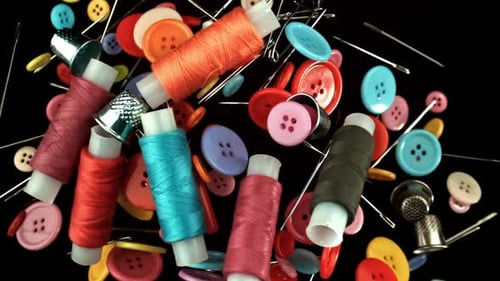 Colorful Sewing Notions: Buttons, Thread, Needles on Black