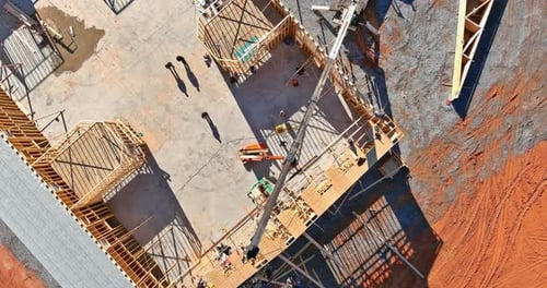 Al instalar las vigas del marco de construcción de una casa de madera sin terminar, la grúa sostiene las cerchas de madera