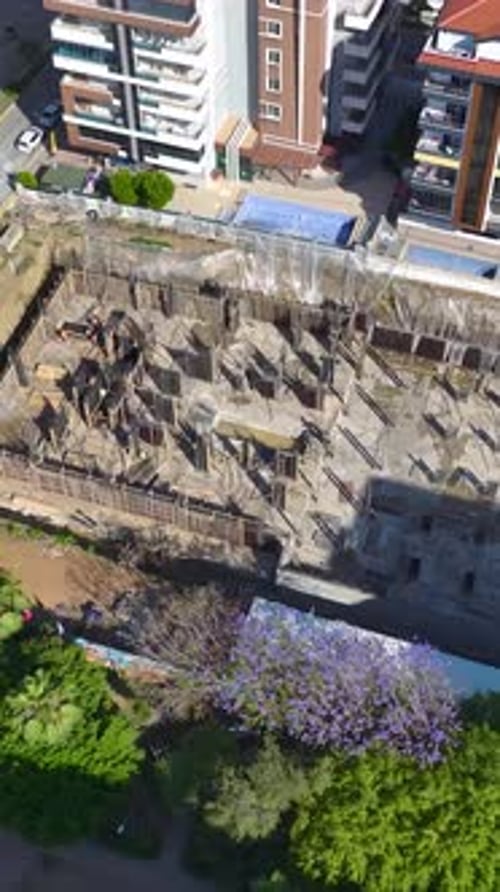 Vertical Video Active Construction Site with Workers Building Walls and Advancing the Structure with