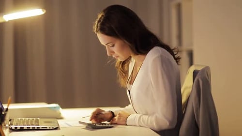 Overworked hispanic businesswoman completes tax report deadline at night office
