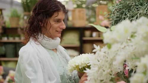 Mature Woman Choosing Artificial Flowers in a Store