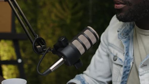 Nahaufnahme eines Podcast-Moderators, der im Mikrofon spricht