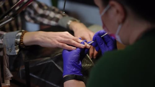 High Angle View Woman Pushing Back the Cuticle on Male Fingers in Slow Motion Closeup Unrecognizable