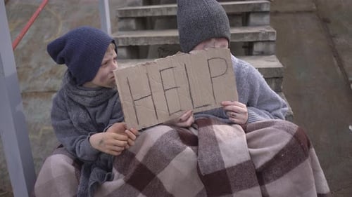 Homeless Boys Sit with a Help Sign on the Stairs in an Abandoned Place Homeless Children with a