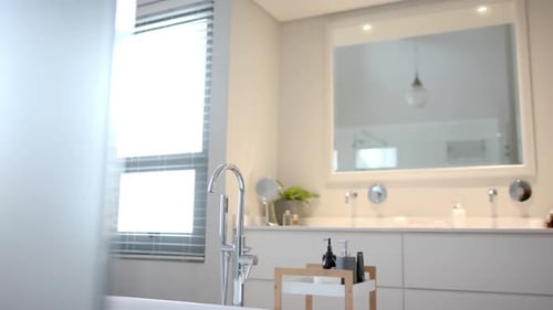Nahaufnahme eines sonnigen weißen Badezimmers mit freistehender Badewanne, Zeitlupe
