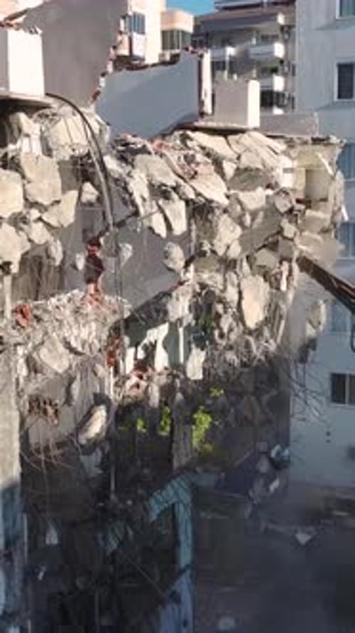 Vertical Video An Excavator with a Hydraulic Breaker Clears an Aging Building Preparing the Site for