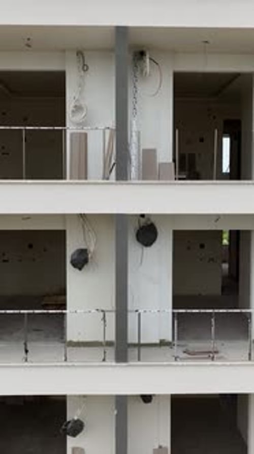 Vídeo vertical: Etapas finales de la construcción de viviendas: instalación de ventanas y elementos de fachada