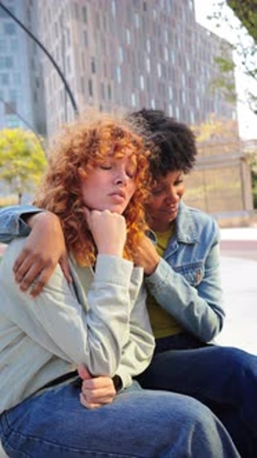 Friends Comforting Each Other in an Urban Setting