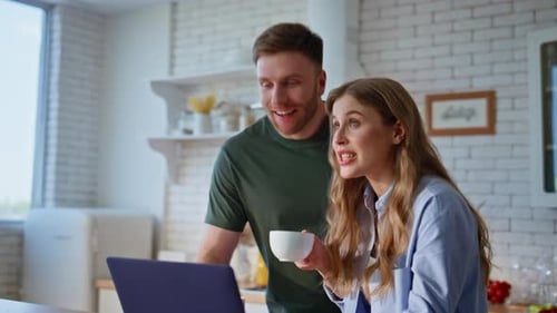 Happy Couple Using Laptop in Bright Kitchen