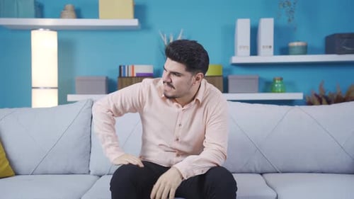 Frustrated Man Sitting on Couch Indoors