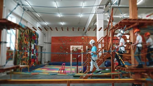 Brave Children Walk Across a Hanging Bridge in a Rope Park