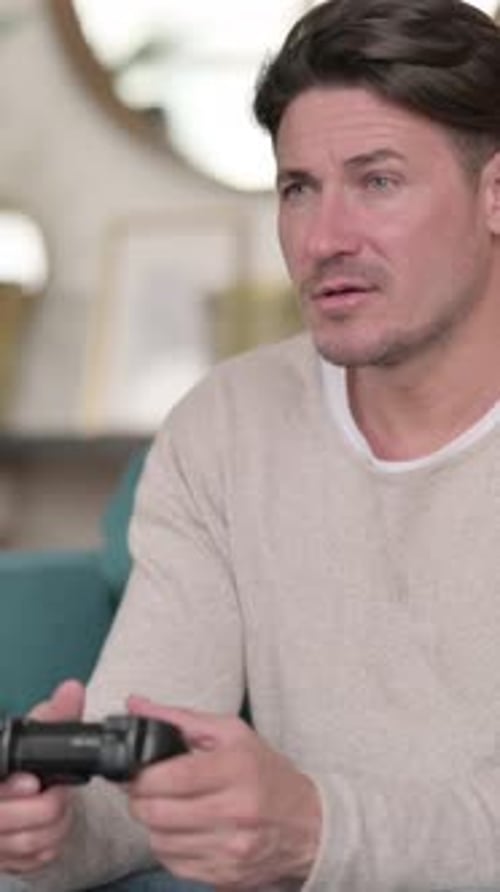 Excited Man Plays Video Game With Controller At Home