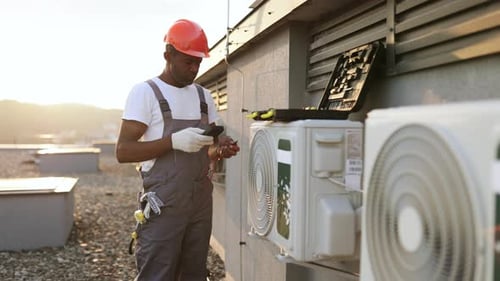 Beschäftigter Mechaniker überprüft den Spannungspegel in der Klimaanlage