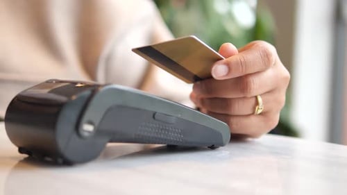 a Hand Making a Contactless Payment with a Credit Card at a Pos Terminal