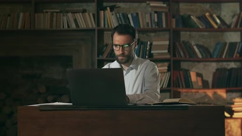 Young Businessman Looks at Papers and Rejoices The Accountant Looks at the Reports and Smiles The