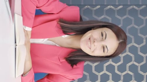 Smiling Woman with Notebook in Workplace