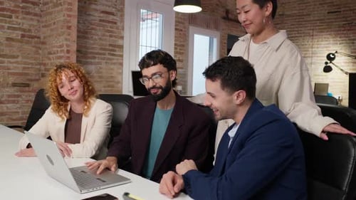 Team Collaborating on Laptop in Modern Office