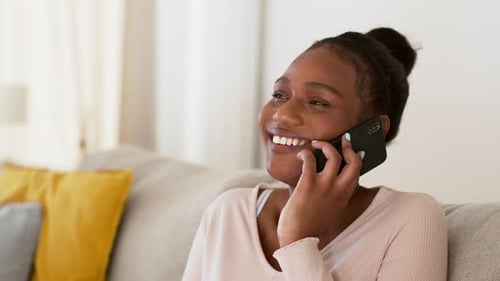 Woman Laughing and Talking on Cell Phone at Home