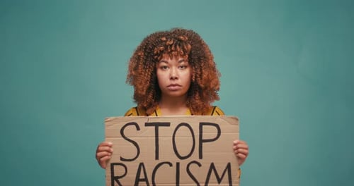 Woman Holds Stop Racism Sign in Studio