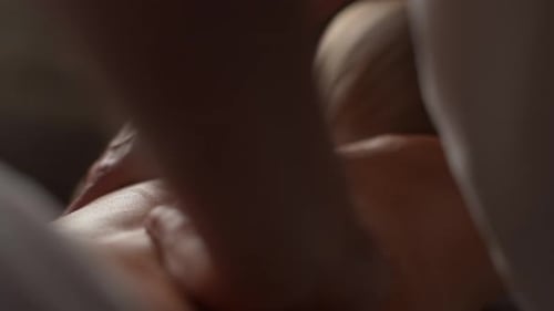 Nahaufnahme eines nicht erkennbaren männlichen Masseurs, der den Rücken einer auf dem Massagetisch liegenden Frau massiert