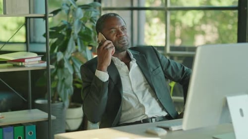 Footage of Confident Busy Middleaged African American Man Talking on Smartphone in Office Portrait