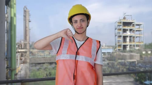 Upset Indian female construction worker showing thumbs down